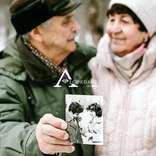 An older couple holding an old photograph together