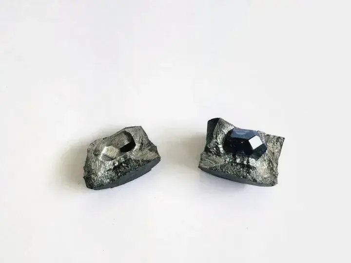 白色背景上的兩塊鑽石原石,一塊透明,一塊深藍色