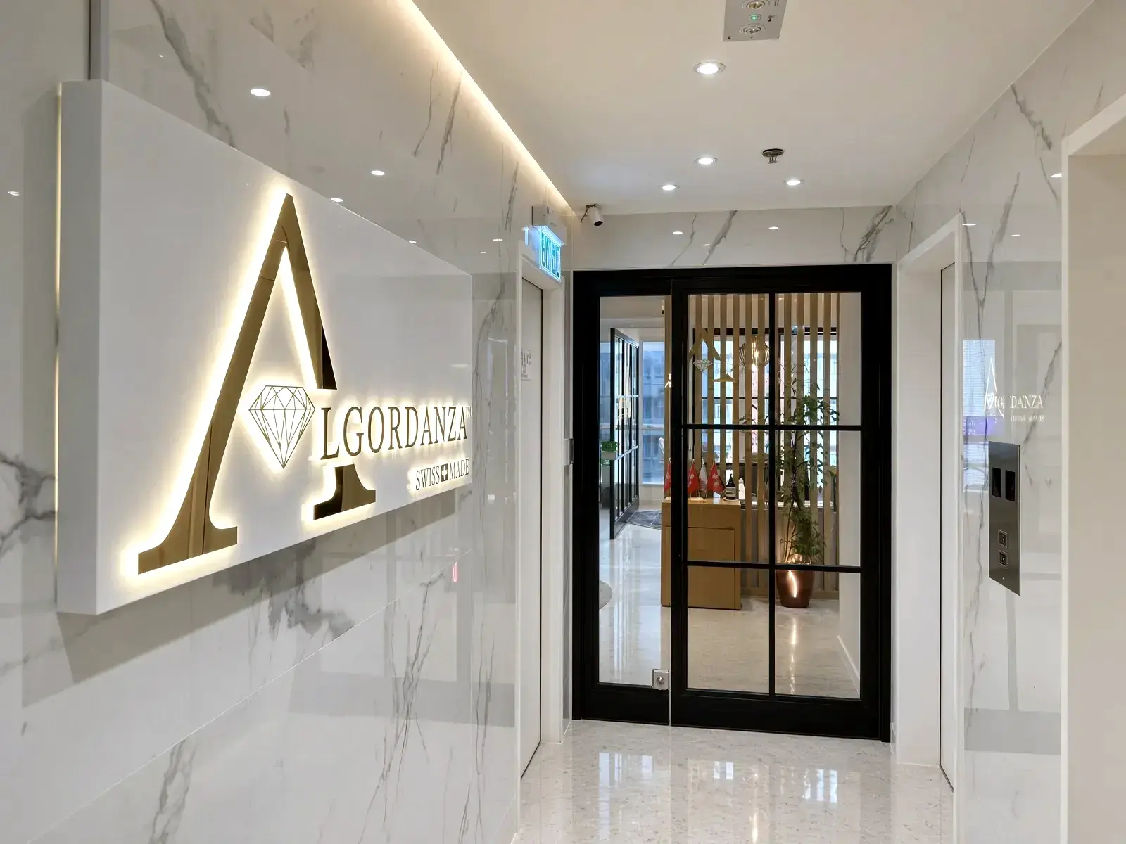 Entrance to the Algordanza showroom in North Point, with the lit Swiss Made sign beside the glass door
