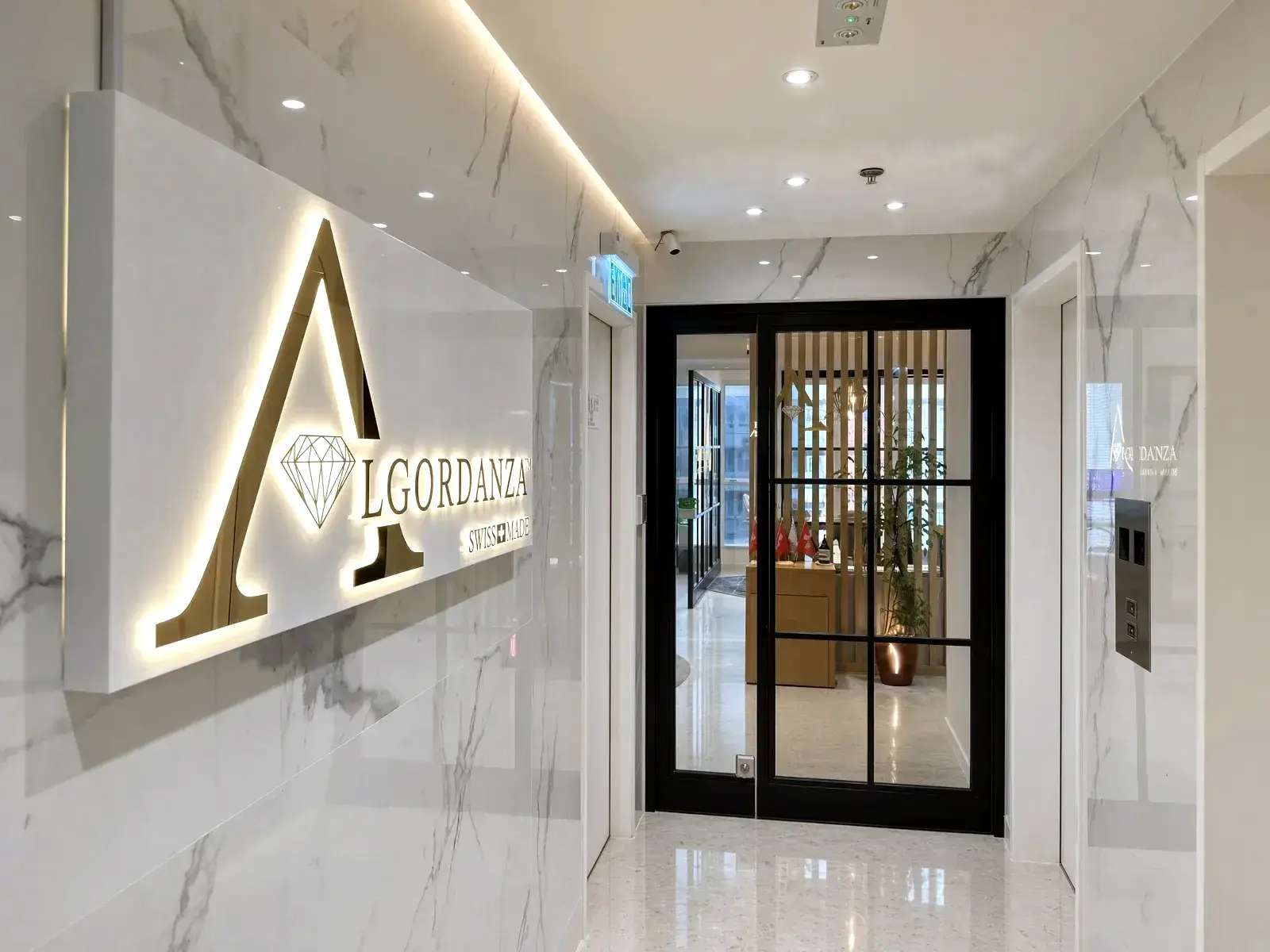 Entrance to the Algordanza showroom in North Point, with the lit Swiss Made sign beside the glass door